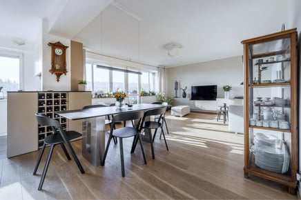 Světlý luxusní interiér s jídelnou obývacím pokojem a dřevěnou podlahou.